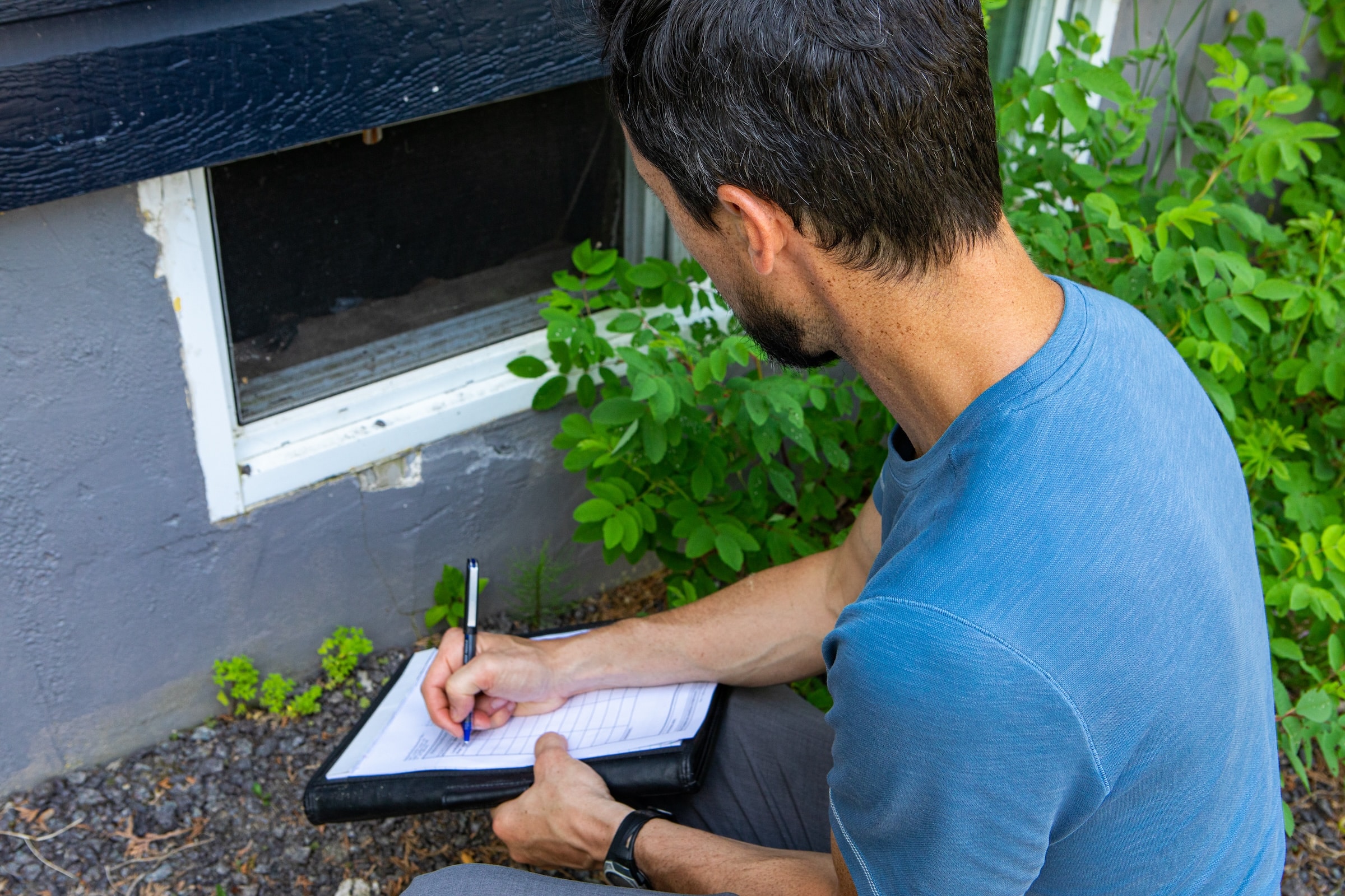 Contractor conducting a thorough home assessment and writing notes on clipboard.