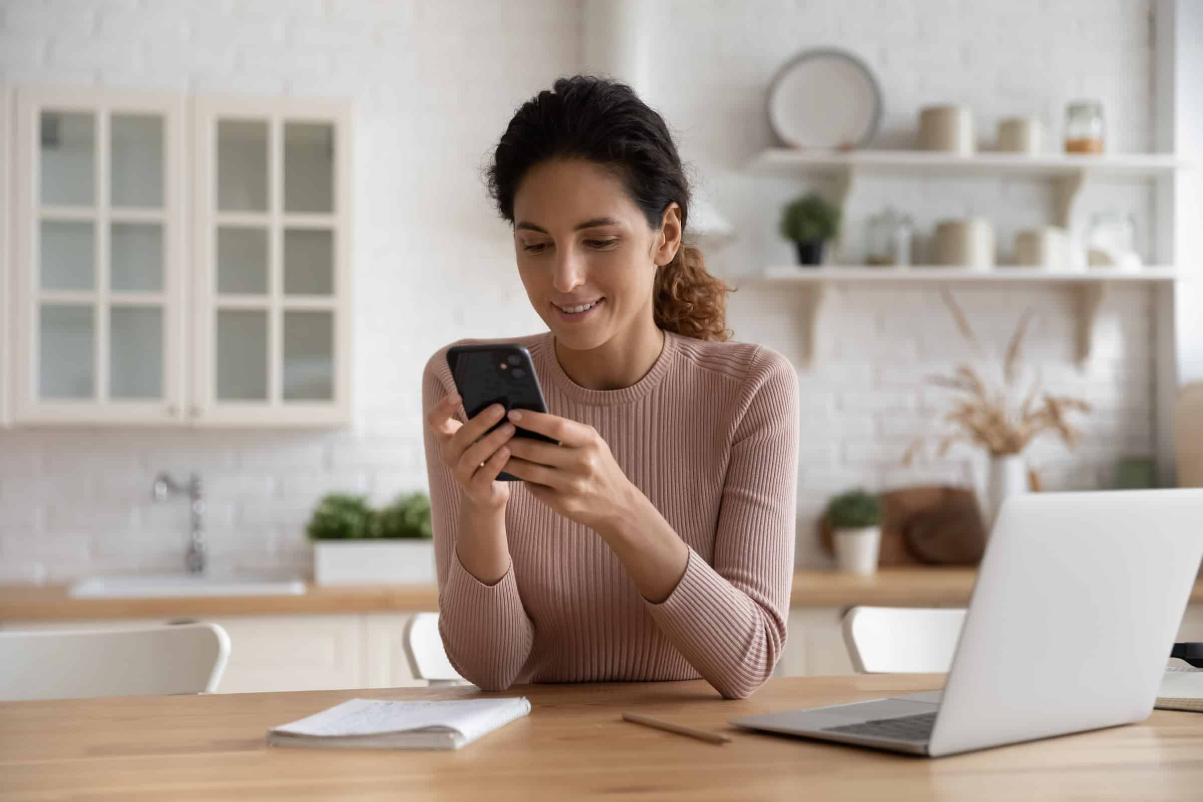 Woman calling on phone from her dining room table